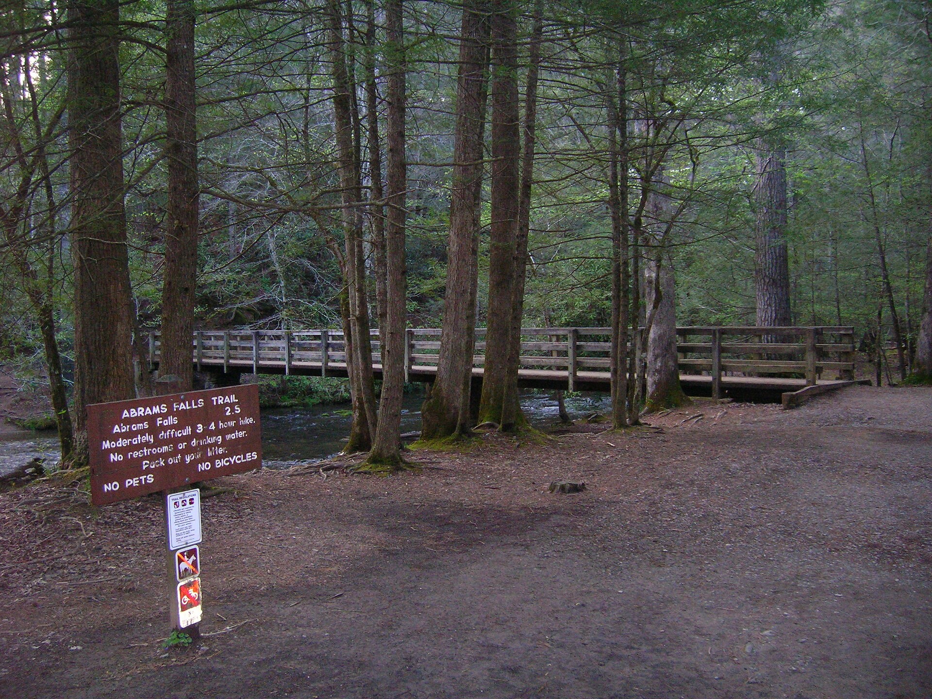 Wooden bridge and trailhead sign at the start of the Abrams Falls Trail off Cades Cove Loop Road