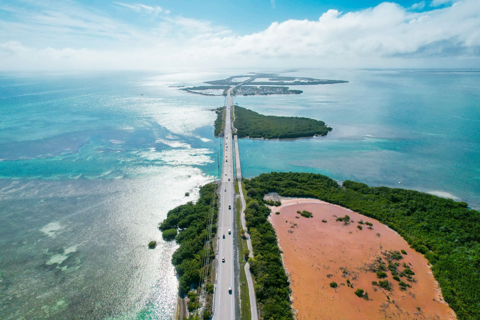 An aerial view of a long highway crossing open ocean water.