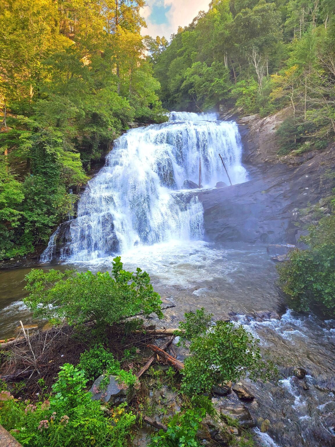 Bald River Falls pouring over a broad rock face into the river below, framed by green trees in Cherokee National Forest