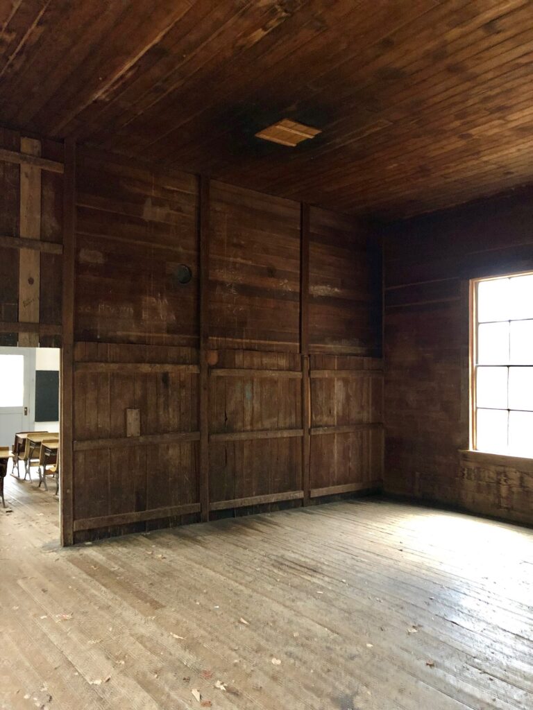 Wood-paneled interior of the historic Beech Grove School building in Cataloochee Valley