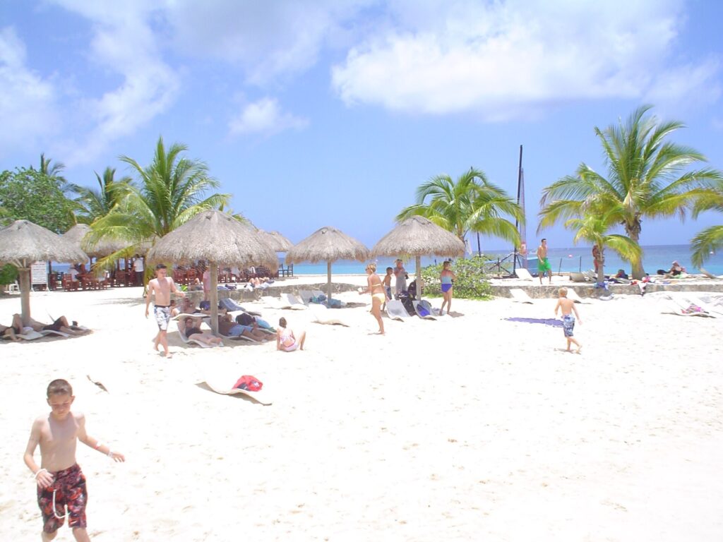 Palapas and swimmers on the beach at Chankanaab Park, Cozumel, Mexico