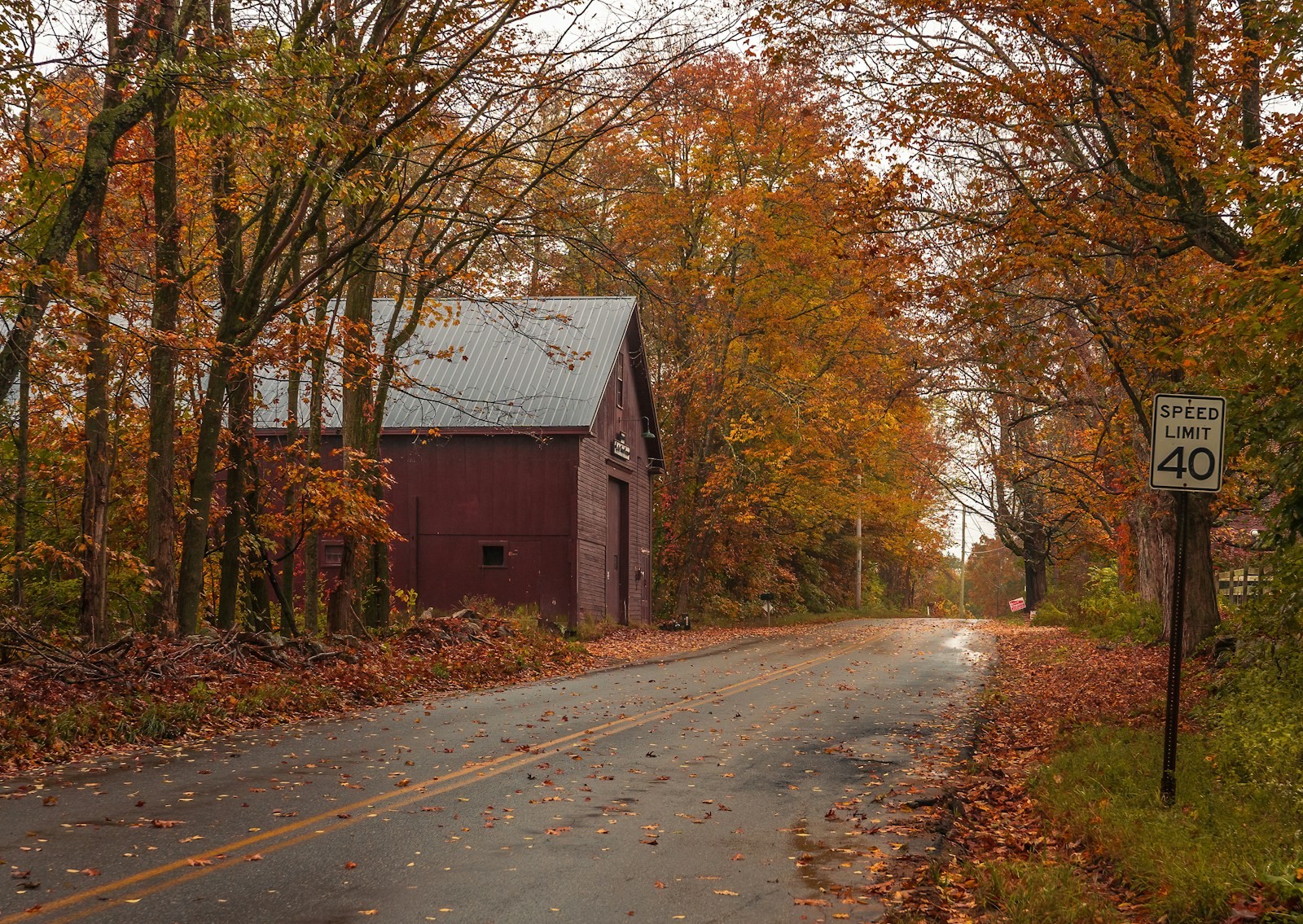 A country road with a barn in the background.