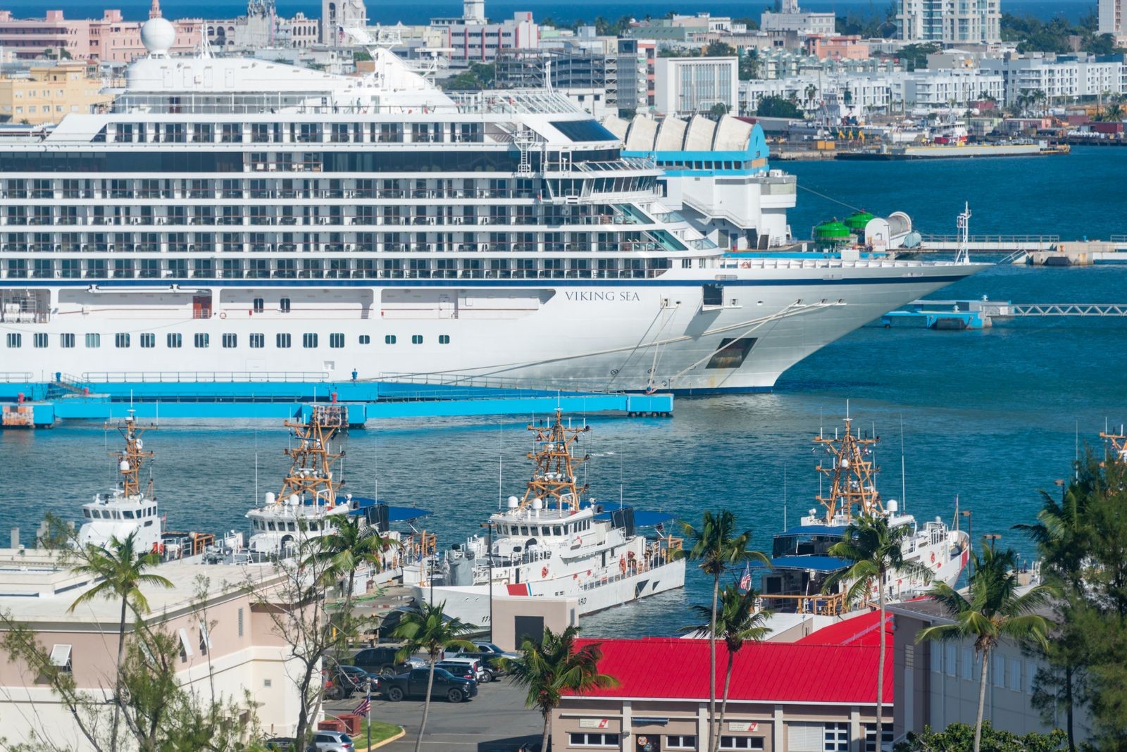 A large cruise ship docked at an urban waterfront port