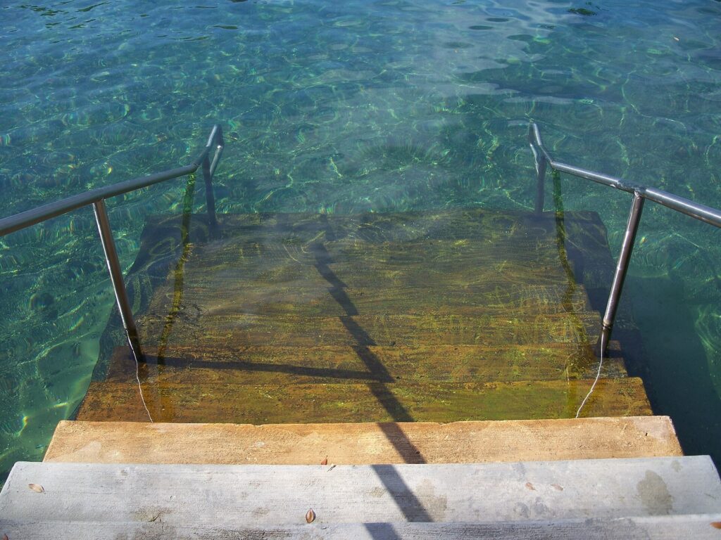Stone steps lead down into clear turquoise spring water