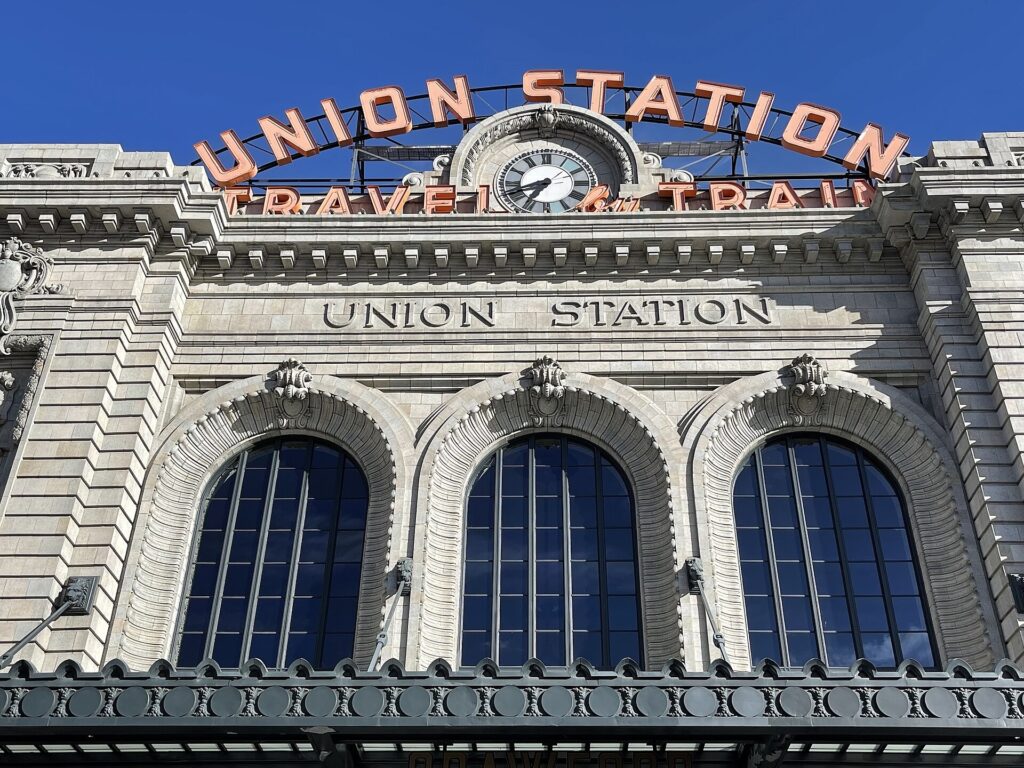 The front of Denver Union Station with its Union Station sign and clock