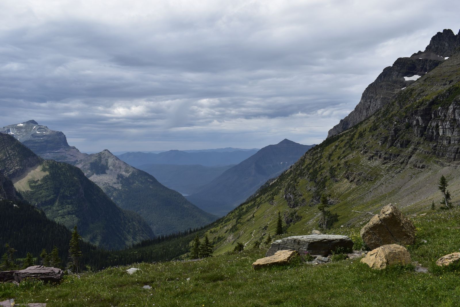 A mountain valley opens up beneath cloudy skies in Glacier National Park