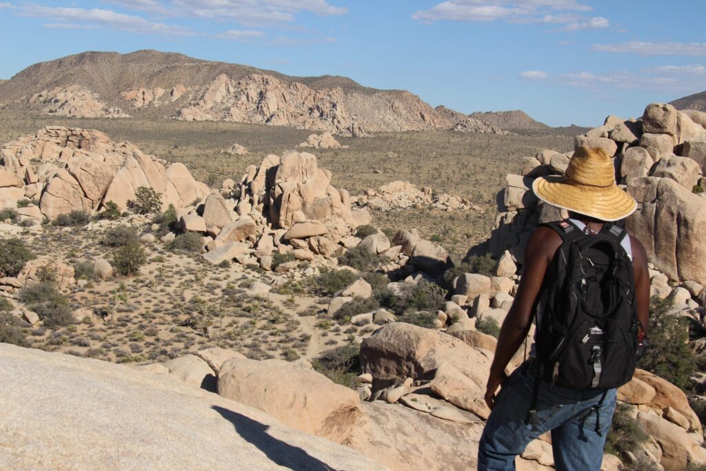 A hiker on the Hidden Valley trail among boulders in Joshua Tree National Park