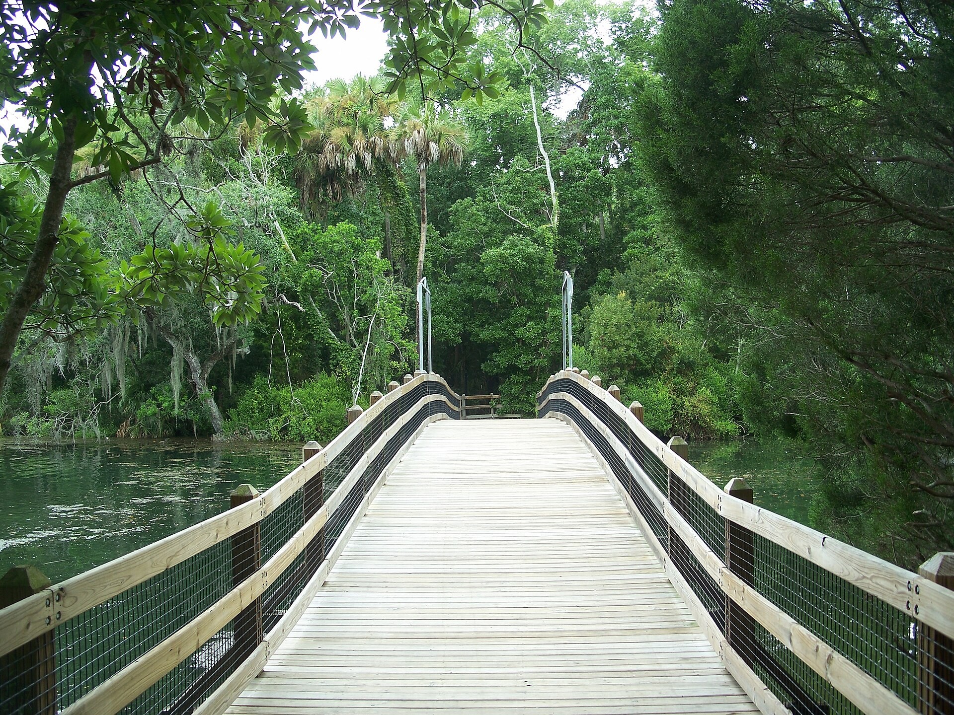 A wooden boardwalk bridge over the clear spring water at Homosassa Springs Wildlife State Park