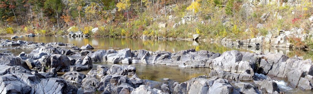 Visitors picking across the rock chutes at the head of the shut-ins on the East Fork Black River