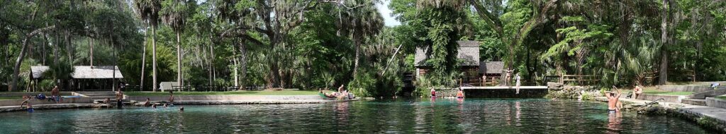Wide view of swimmers and the shoreline buildings at Juniper Springs recreation area