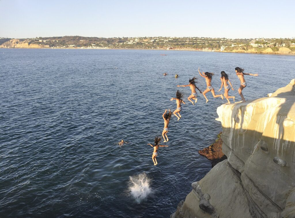 Cliff jumpers leaping into the water at La Jolla Cove