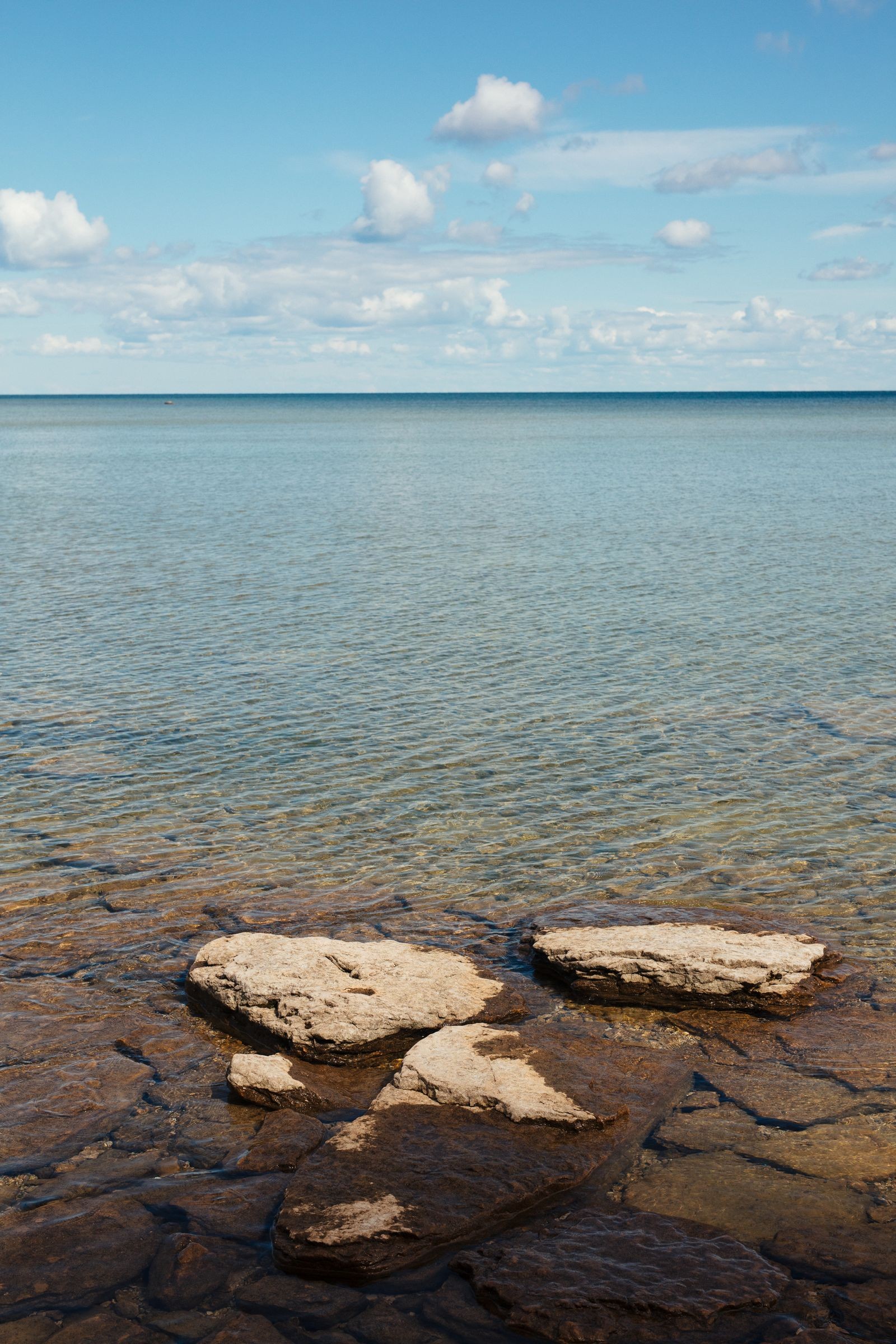 Clear water over flat limestone rocks along a Lake Michigan shoreline in Wisconsin