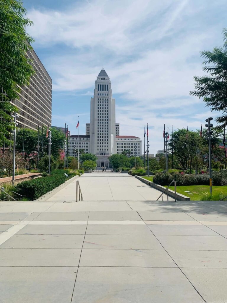 Los Angeles City Hall seen straight down the lawn of Grand Park in the Civic Center