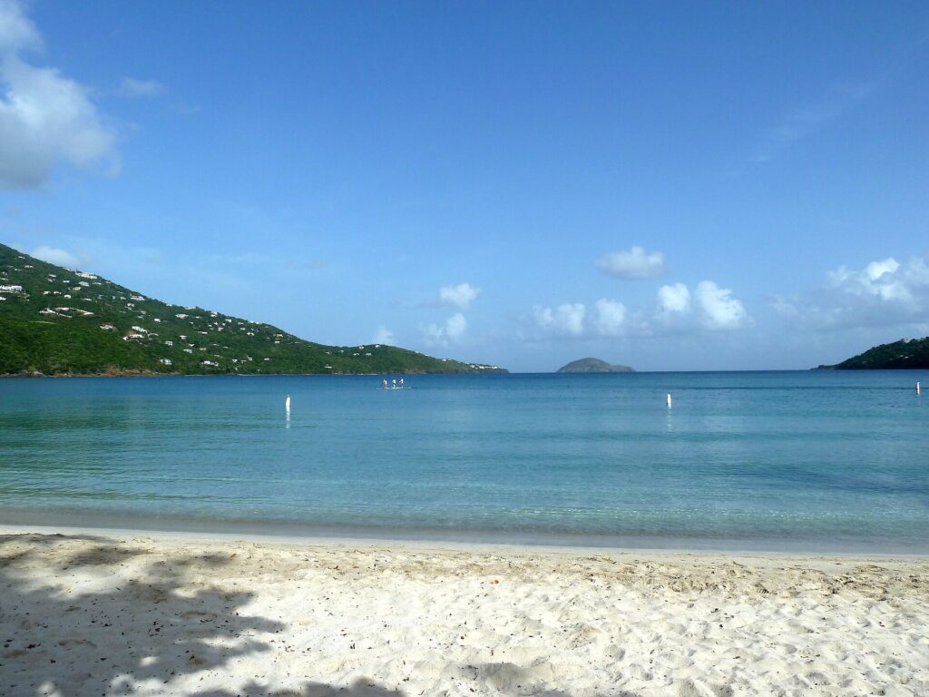 Magens Bay's white sand and calm turquoise water, framed by green hills on St. Thomas