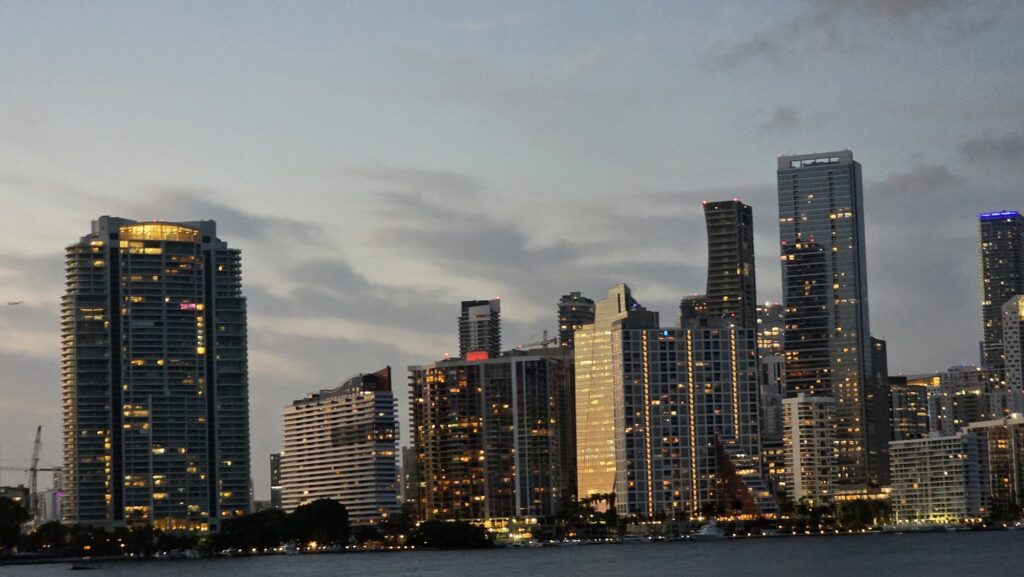 Brickell towers lit up at dusk, where the drive south to the Keys begins