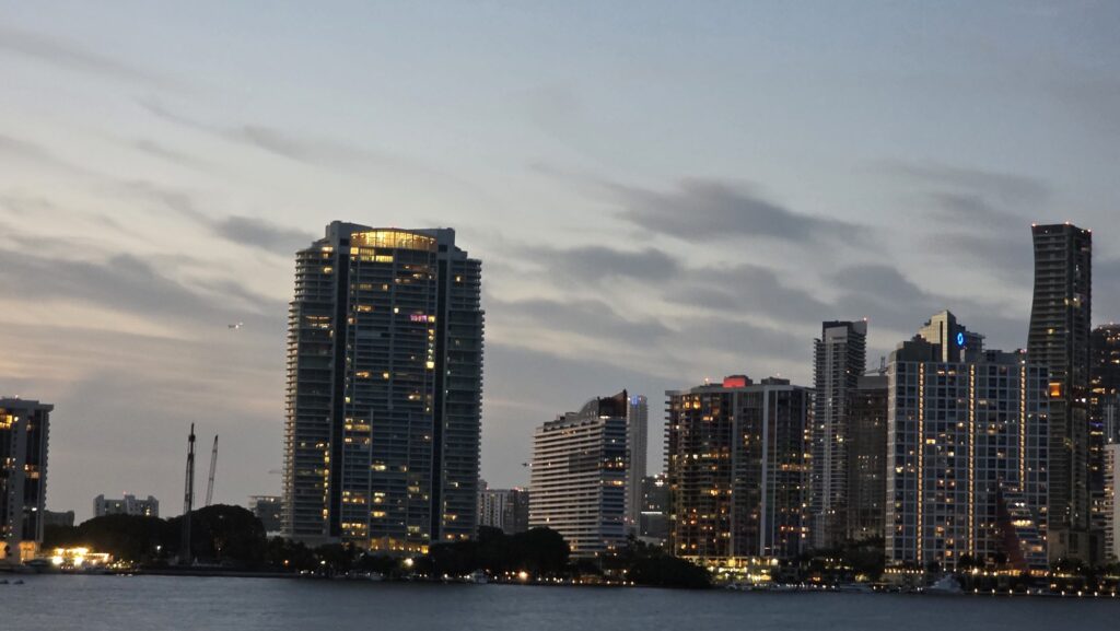Brickell condo tower lit at dusk across Biscayne Bay