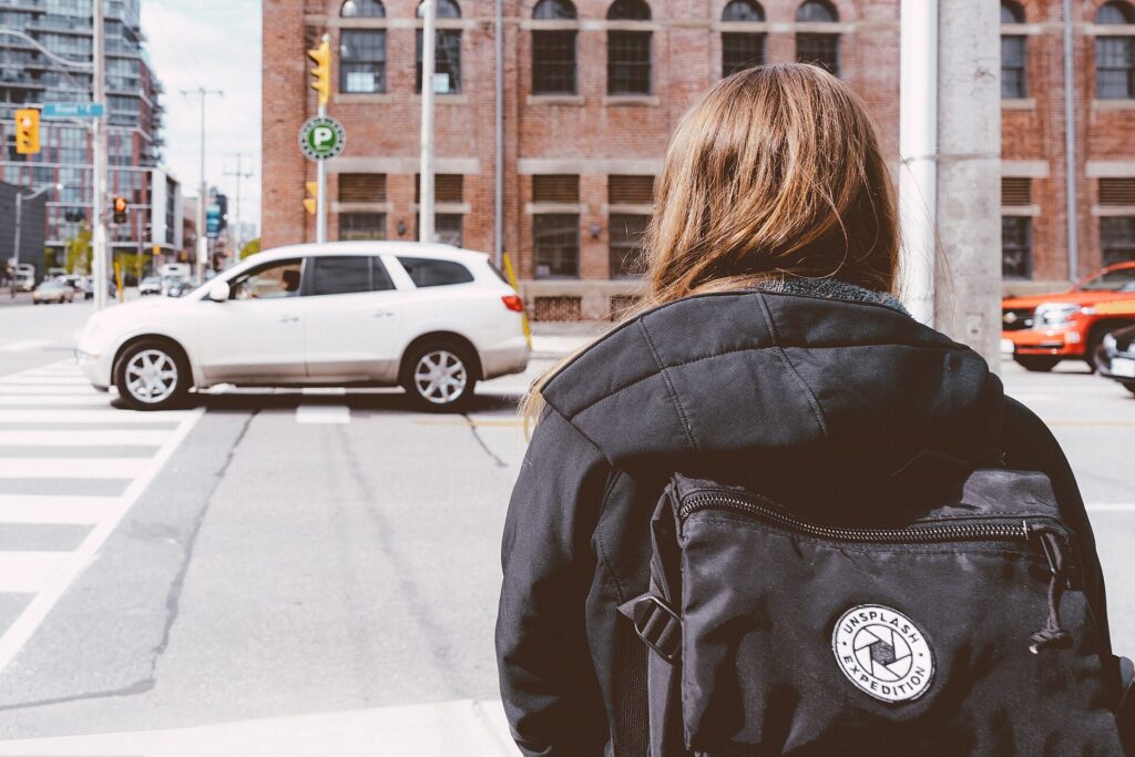 A travel backpack worn while walking on a city street