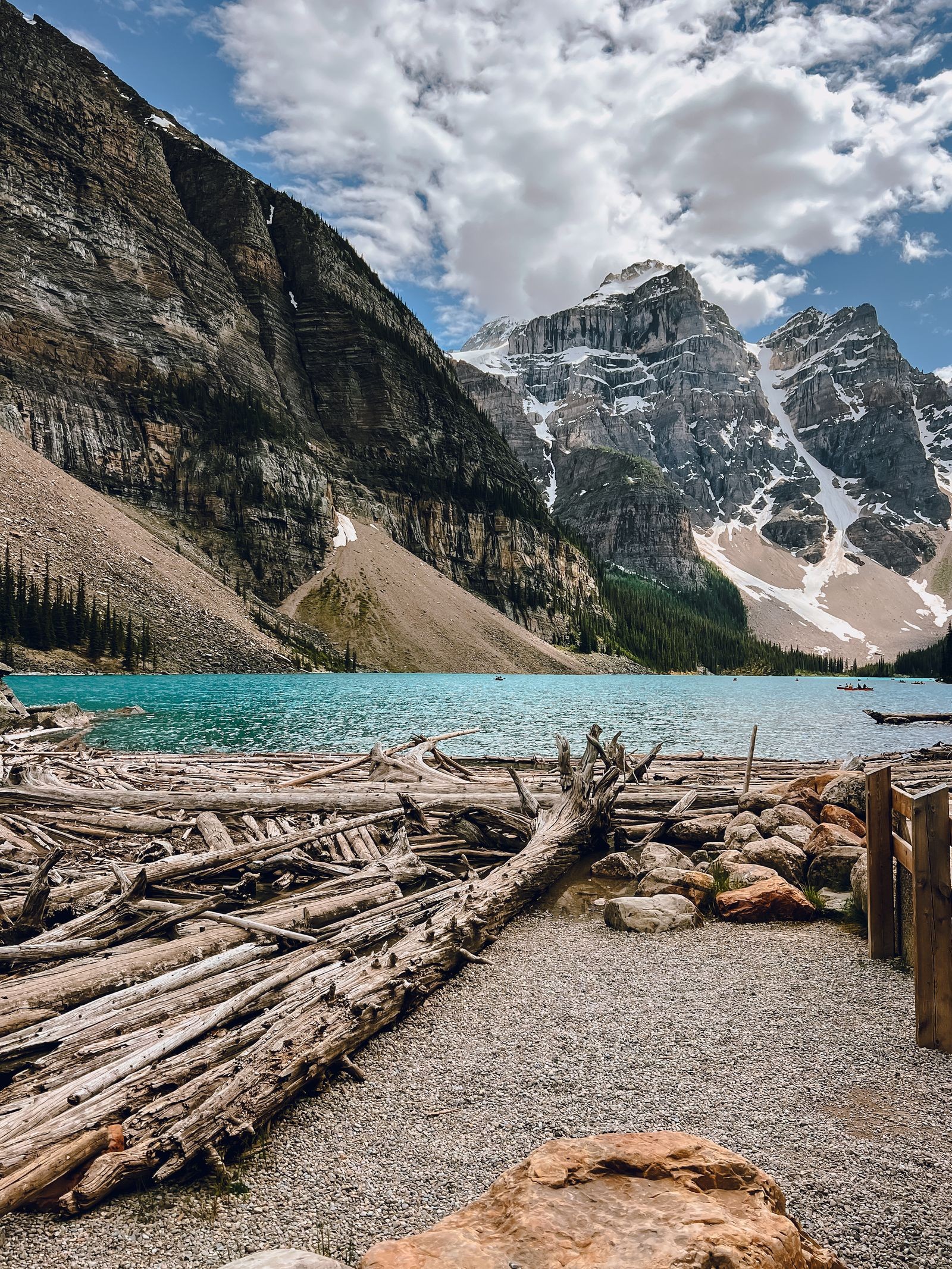 Moraine Lake's turquoise water framed by driftwood and the Valley of the Ten Peaks