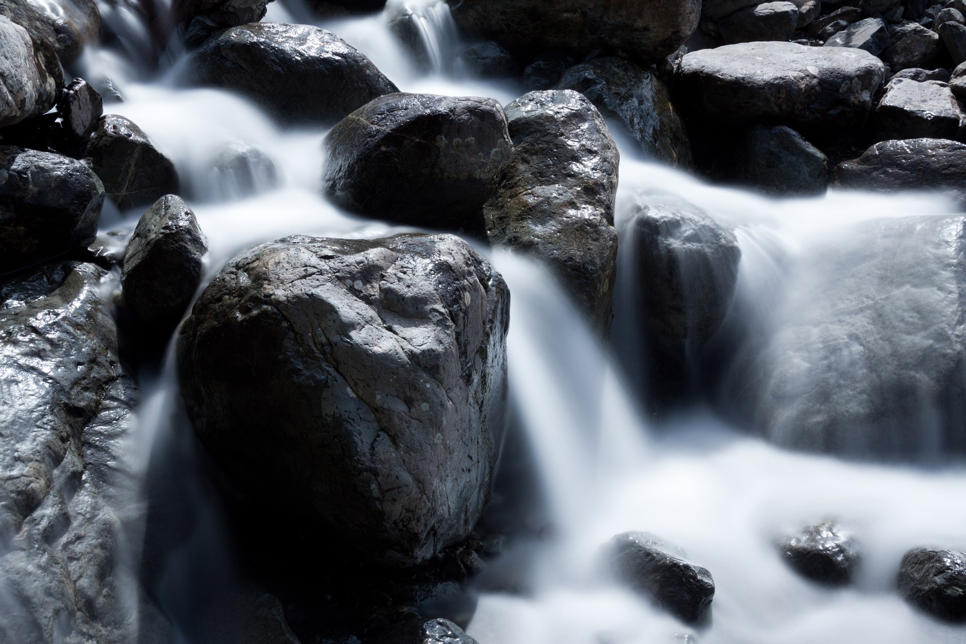Water cascading over boulders in a mountain creek