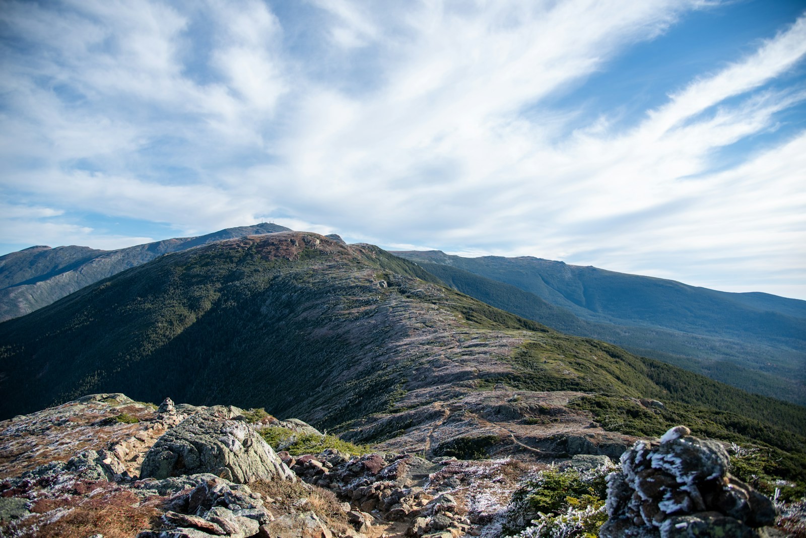 A view of a mountain range seen from the top of a hill.