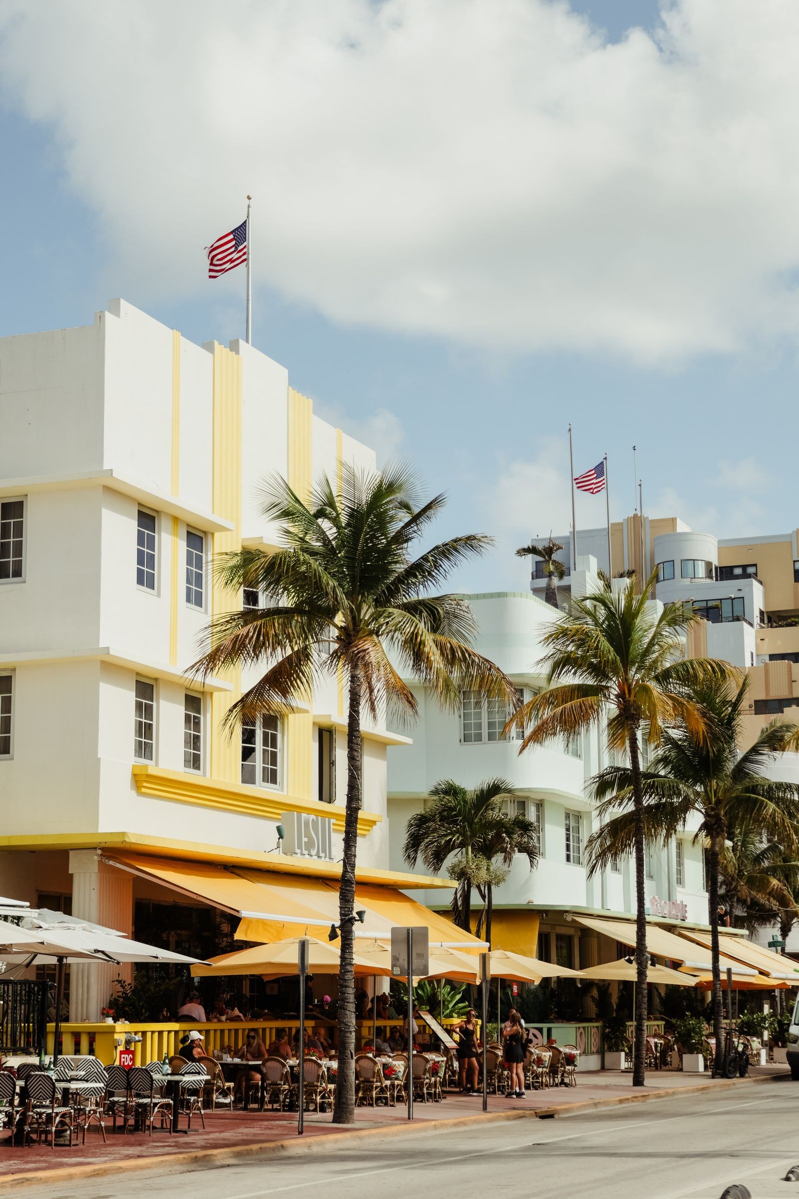 Pastel Art Deco hotels with palm trees and sidewalk cafes along Ocean Drive in Miami Beach