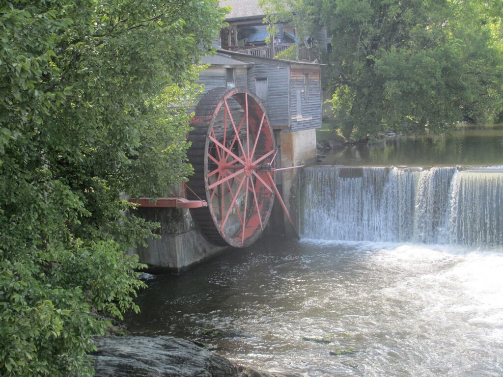 The historic Old Mill waterwheel turning over the Little Pigeon River in Pigeon Forge, Tennessee