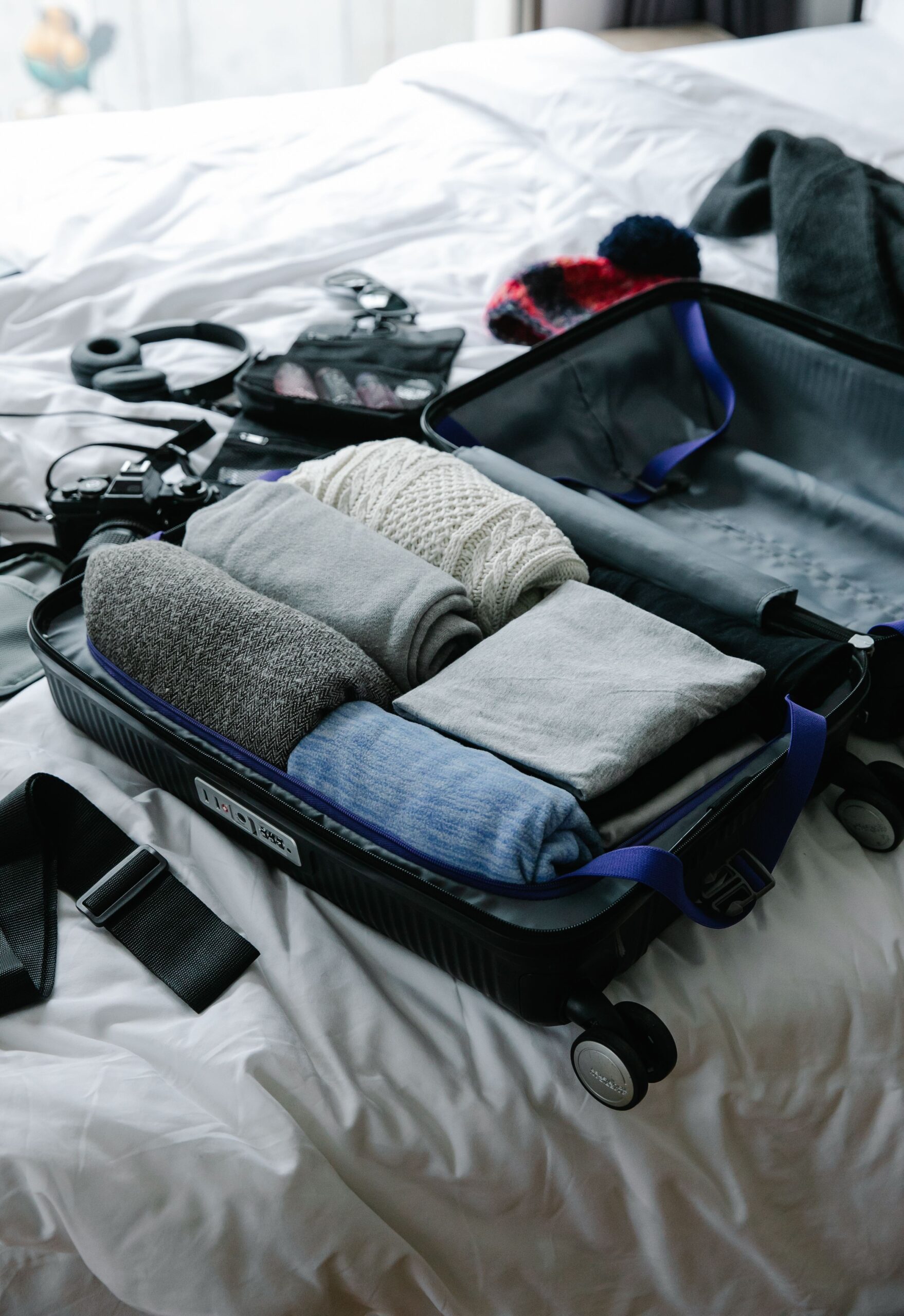 Open suitcase on a bed filled with neatly folded clothes ready for a trip
