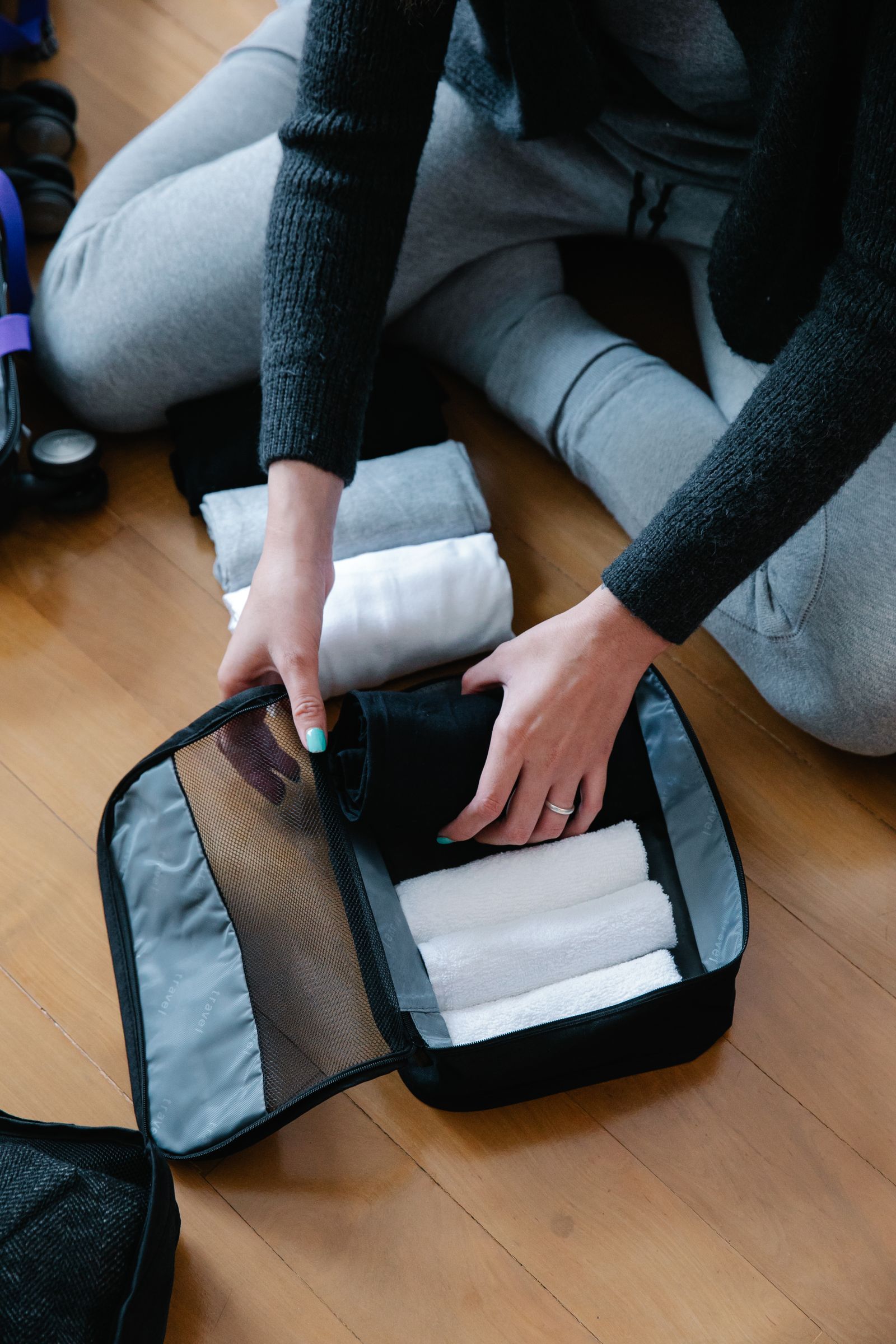 Rolling clothes into a packing cube for a suitcase
