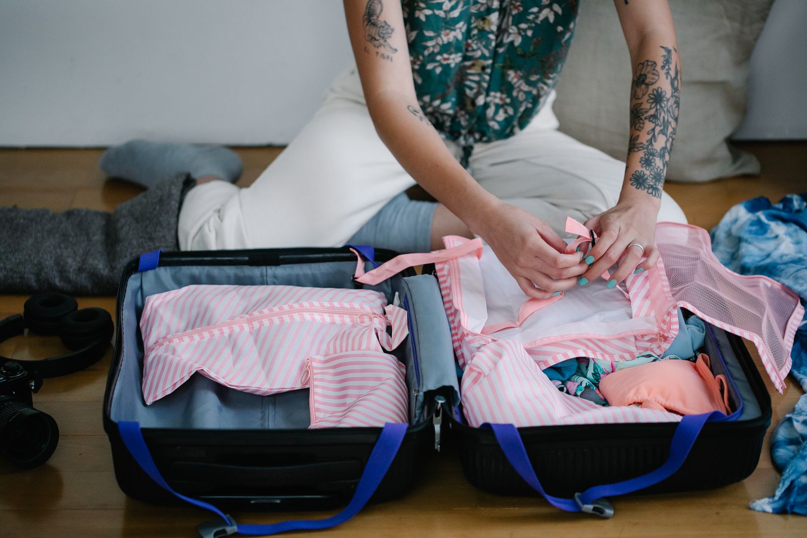 Folding striped packing bags into an open suitcase
