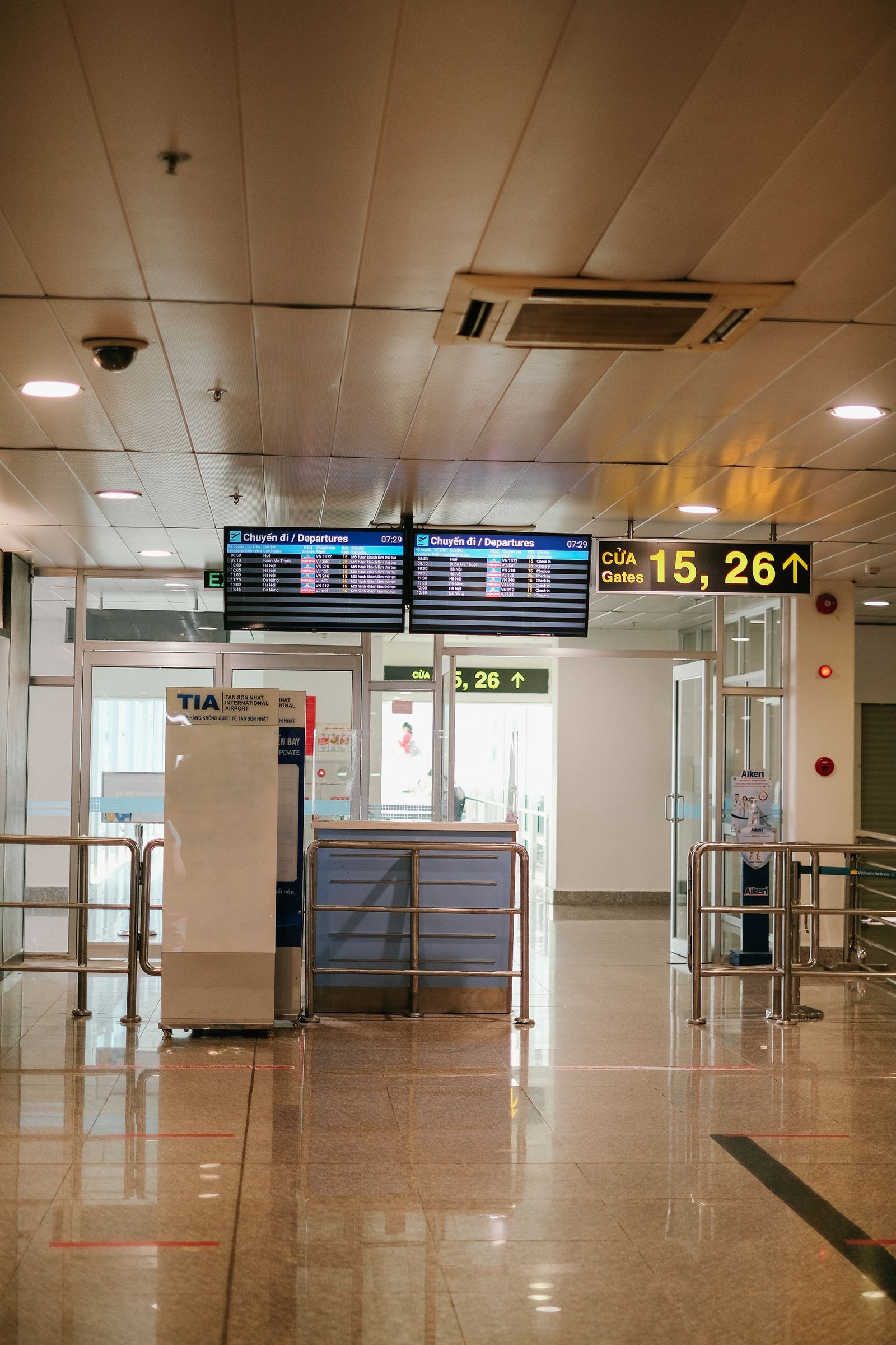 An empty airport gate area sits below the departure boards