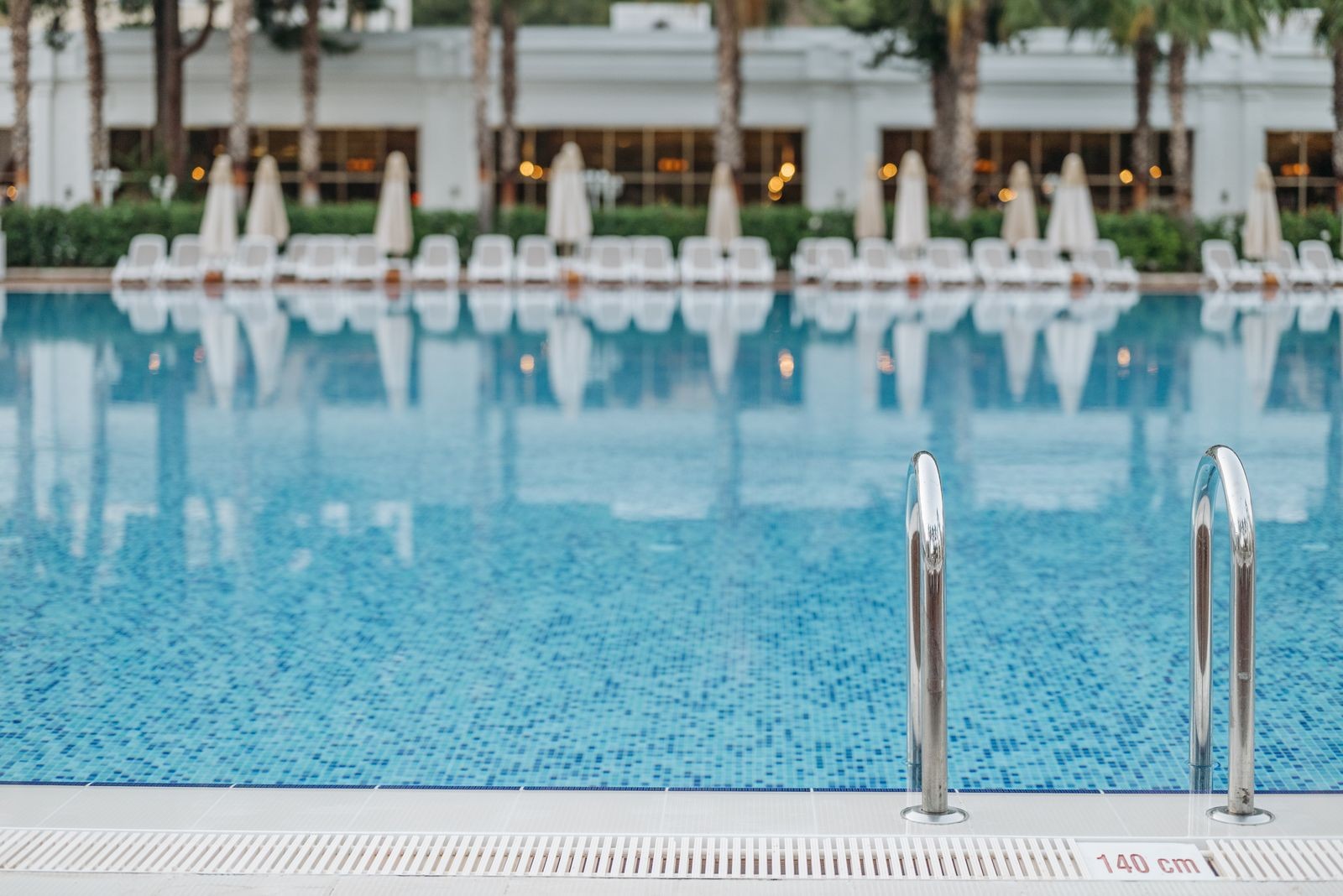 Empty resort swimming pool with lounge chairs