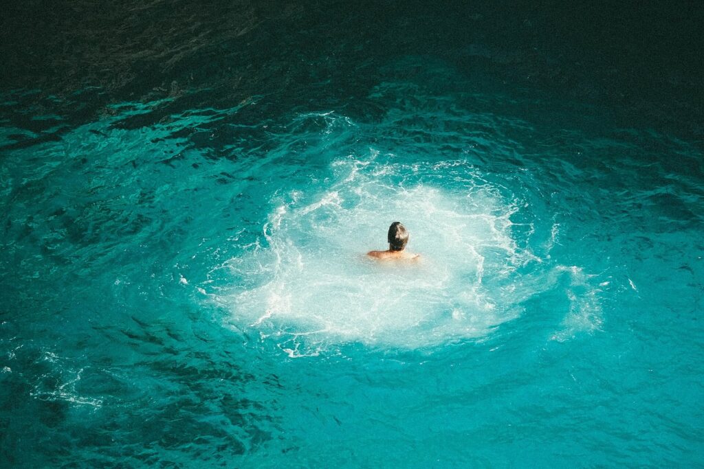 Swimmer in the cove below the cliffs at Rick's Cafe in Negril, Jamaica