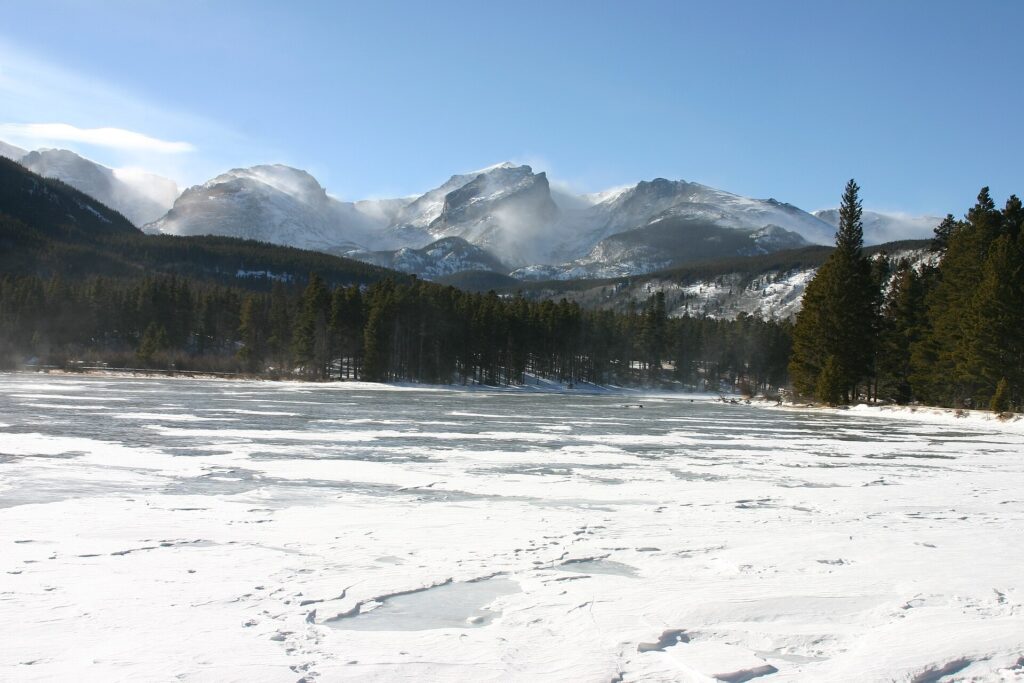 Sprague Lake in winter with snow along its banks at Rocky Mountain National Park