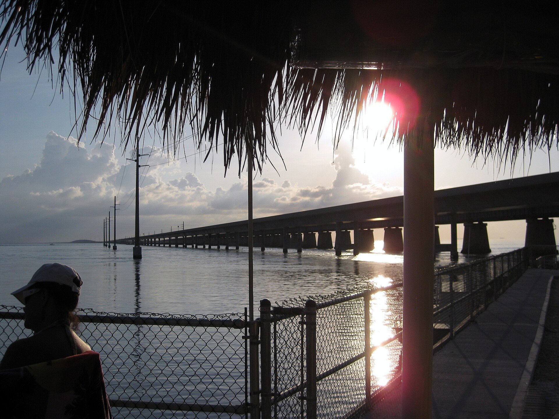 The Seven Mile Bridge at sunset, seen from under a waterfront tiki hut