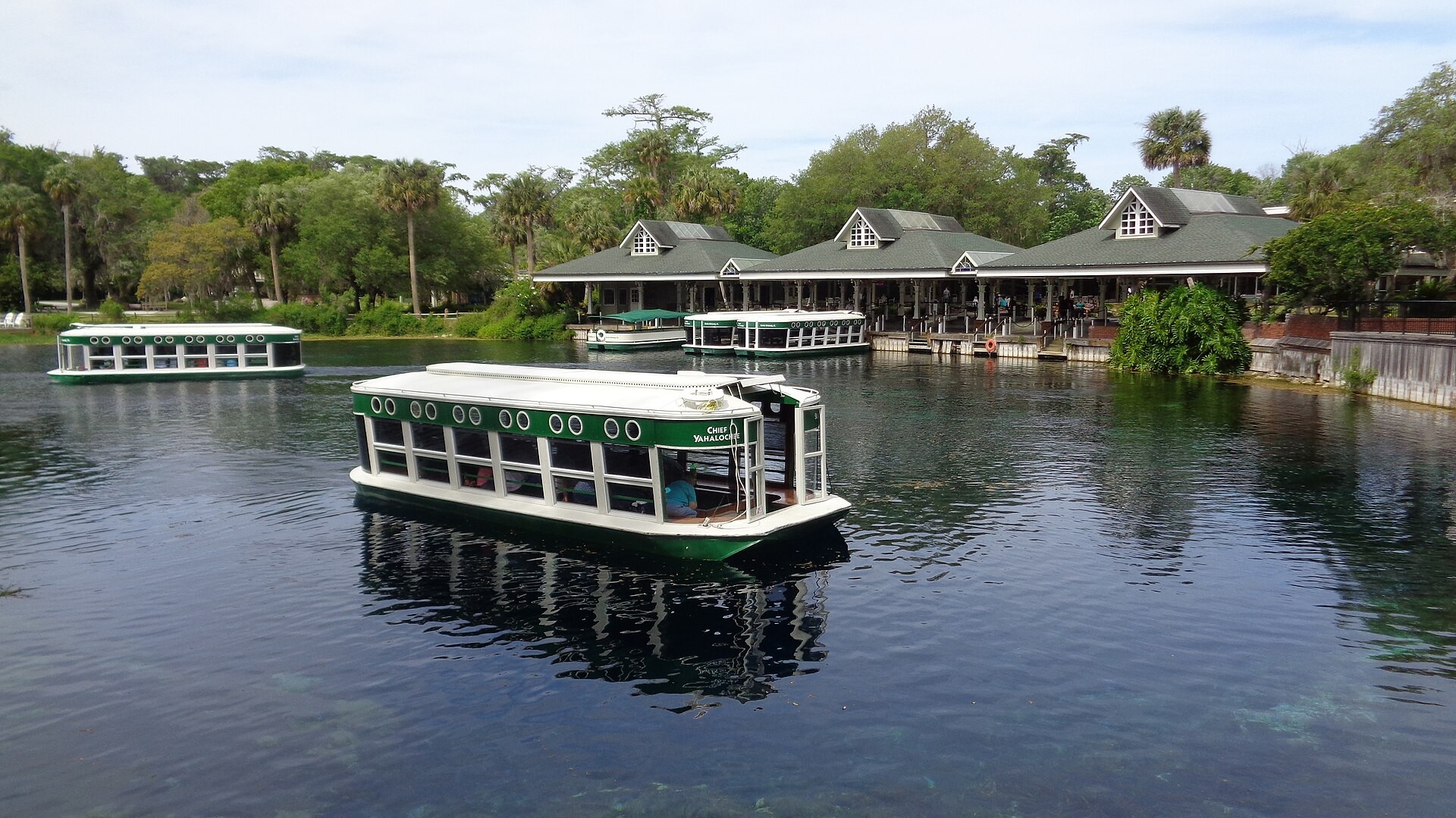 Glass-bottom boats loaded with visitors on the water at Silver Springs State Park