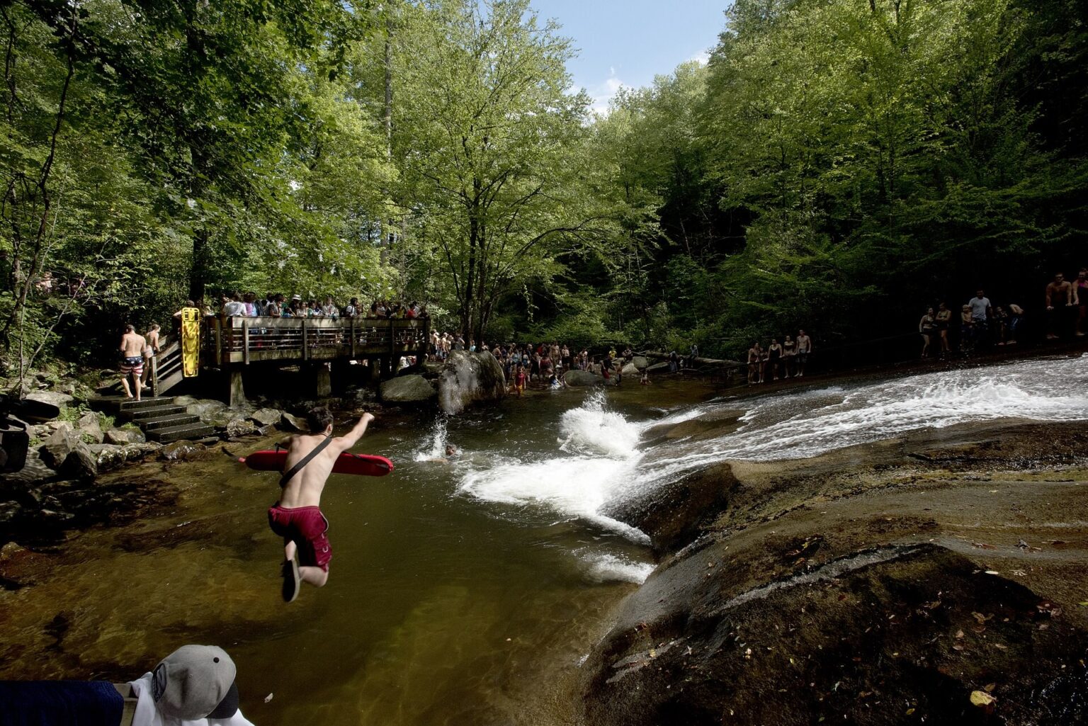 A Forest Service lifeguard jumps into the plunge pool at Sliding Rock in Pisgah National Forest