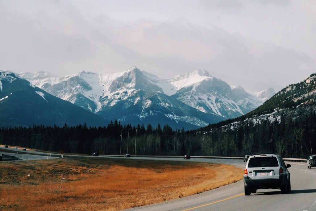 A gray SUV parked on a mountain road