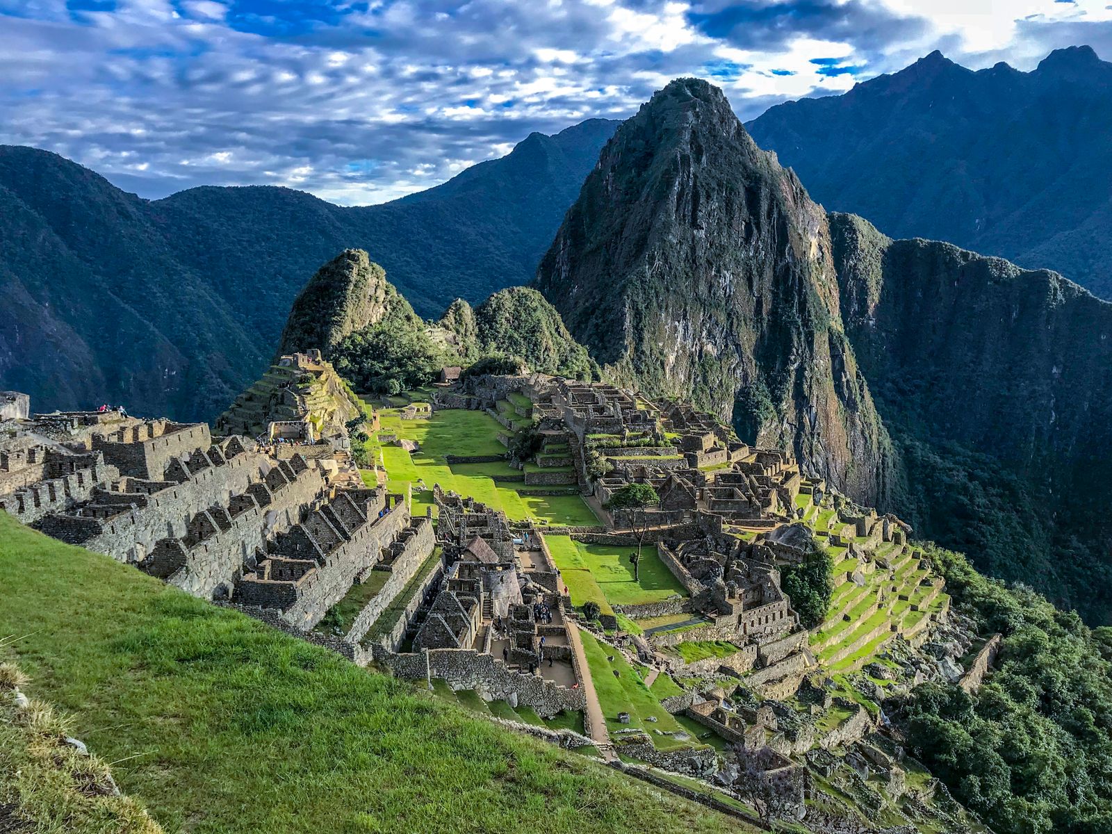 Terraced stone ruins at Machu Picchu against a steep green mountainside
