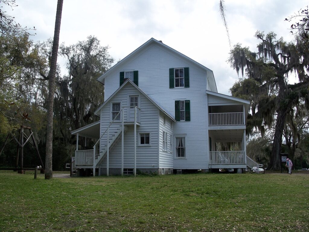 The historic two-story Thursby House surrounded by oak trees at Blue Spring State Park