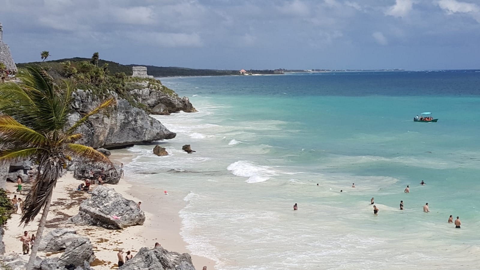 The beach below the Tulum ruins, with the cliff and stone wall above the sand