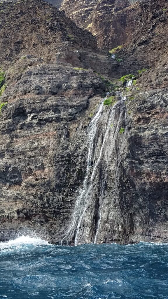 Waterfall dropping straight into the sea along the Na Pali Coast