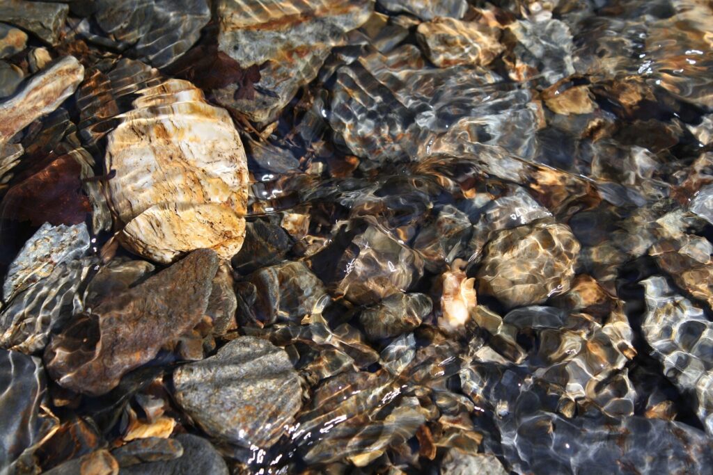 River stones covered by a thin layer of moving stream water