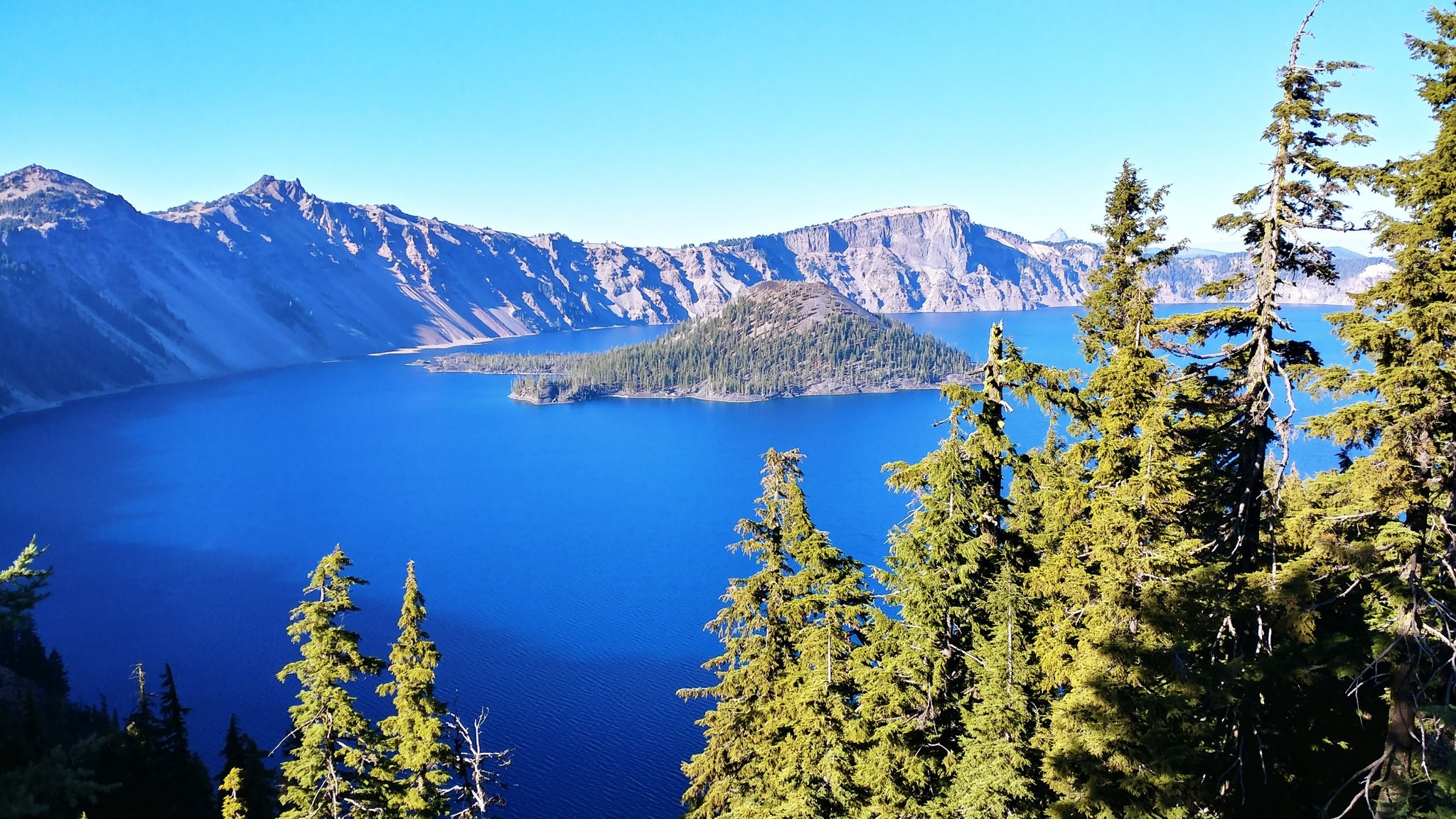 Wizard Island rising from the deep blue water of Crater Lake, seen from the rim
