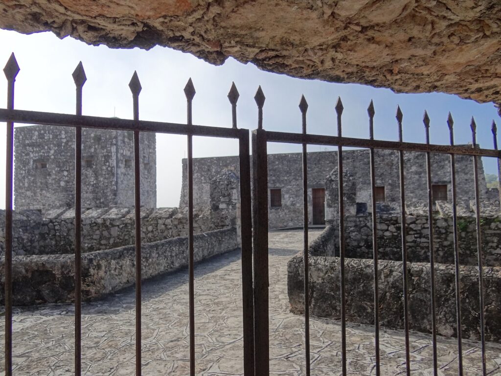 The stone Fort of San Felipe in the town of Bacalar, Quintana Roo, Mexico, seen through an iron gate
