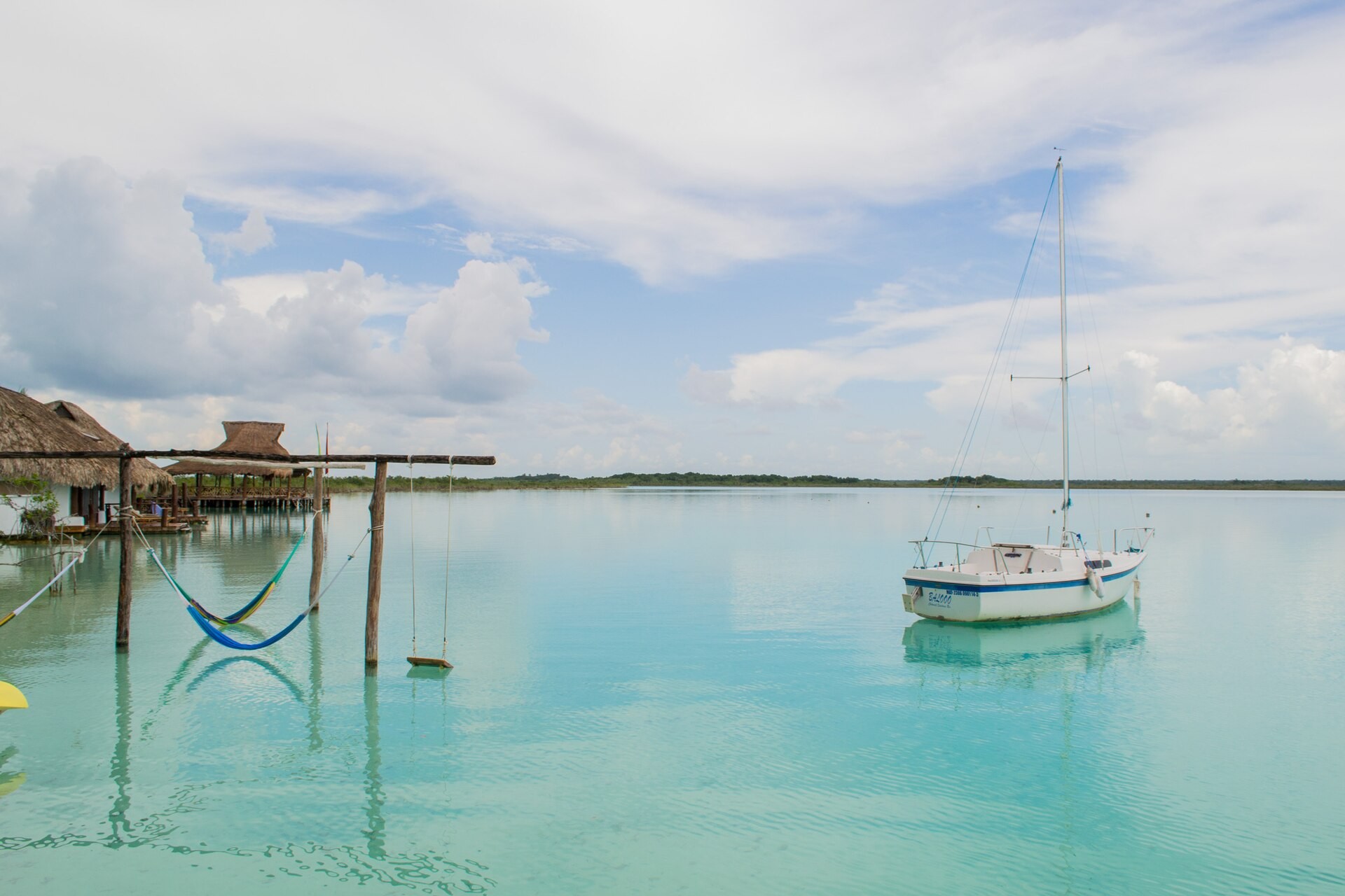 The Bacalar lagoon in bands of turquoise and blue water, seen from the shore in Quintana Roo, Mexico