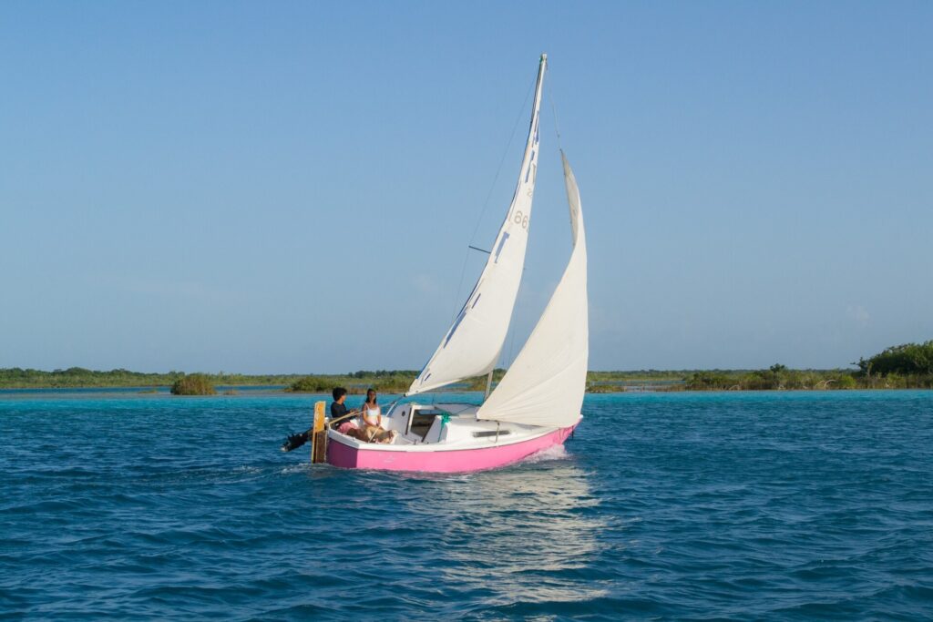 A sailboat on the clear blue water of Laguna de Bacalar in Quintana Roo, Mexico