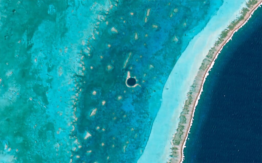 Aerial view of the Great Blue Hole, a dark circular sinkhole in the Lighthouse Reef shallows, Belize