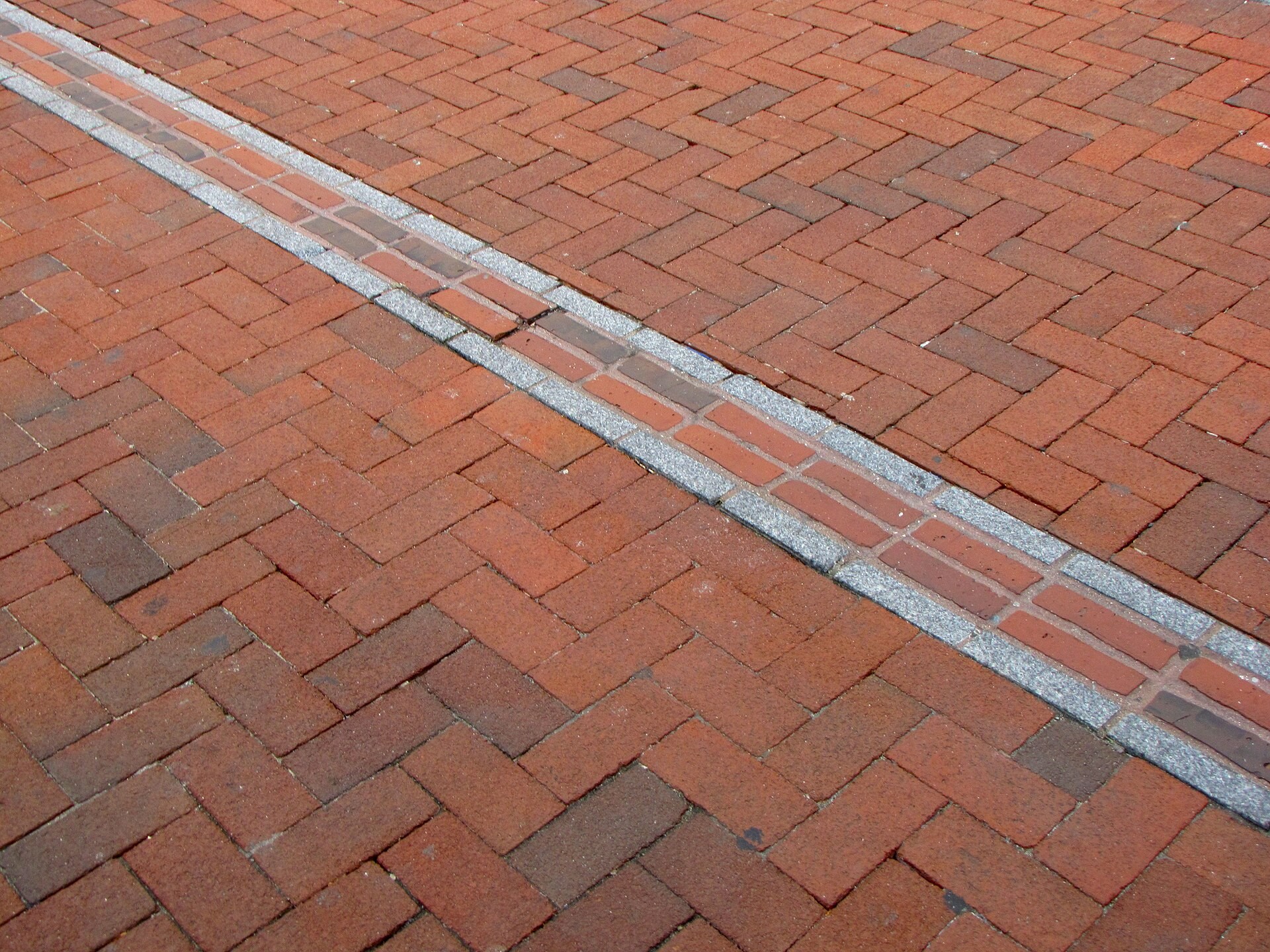 Freedom Trail red brick path on a downtown Boston sidewalk