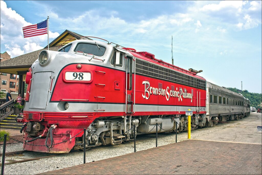 Red and silver Branson Scenic Railway diesel locomotive beside the depot platform in Branson, Missouri