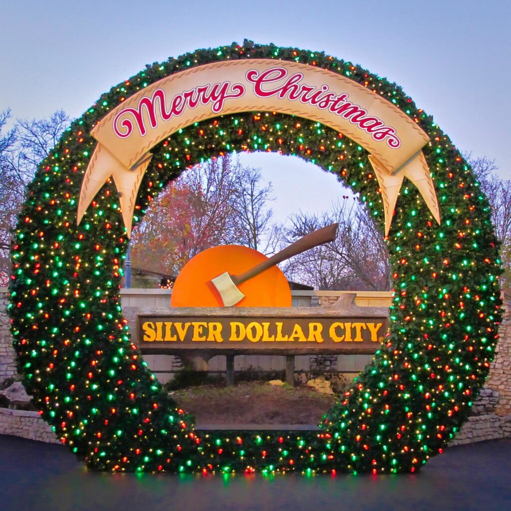 Lit Christmas wreath arch framing the Silver Dollar City sign in Branson, Missouri